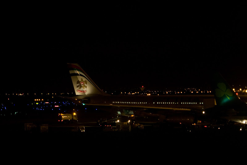 an airplane at night with lights in the background