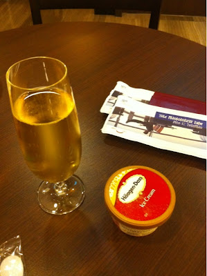 a glass of champagne next to a container of ice cream