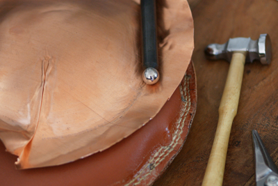 Sherry Cordova metalsmithing copper Adjusting the copper ashtray on a shot bag
