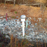 A completed passive landfill gas vent trench and monitoring well at a landfill