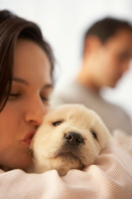 A quick payday advance online can help you, too! Woman kissing a dog with a man in the background.