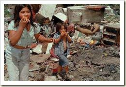 crianças comendo restos no lixo