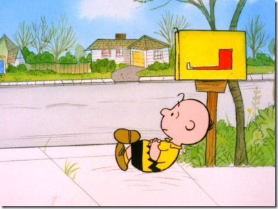 Charlie Brown sitting by the mailbox