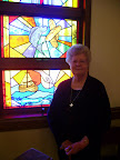 JoAnn Hodgson with the stained glass window commemorating the Miracle of the "Loaves and Fishes"