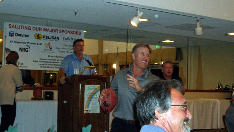 John Elway prepares to throw a pass across the banquet room to one of the auction winners of the autographed football. John Elway prepares to throw a pass across the banquet room to one of the auction winners of the autographed football.