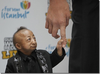 World's shortest man He holds the finger of world's tallest man Kosen as they pose for photographers during a promotional event in Istanbul January 14,2010