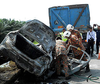 Proton Persona rentung selepas terbakar dalam kemalangan dengan sebuah lori di Lebuhraya Utara Selatan hari ini.