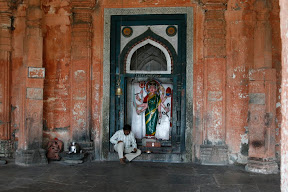 At one end of the square stands the temple, and a bell for praying.