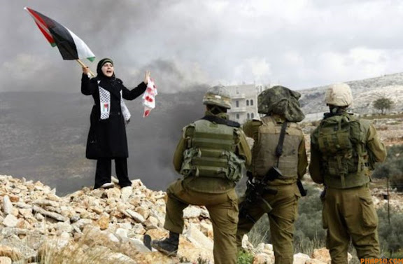 RNPS IMAGES OF THE YEAR 2009 - A Palestinian stands in front of Israeli soldiers during a protest in the West Bank village of Bilin near Ramallah against Israel's offensive in Gaza January 8, 2009. Several rockets fired from Lebanon struck northern Israel on Thursday, slightly wounding two people, police and medics said, in attacks seen as linked to Israel's war on Hamas Islamists in the Gaza Strip. REUTERS/Eric Gaillard (WEST BANK CONFLICT POLITICS)