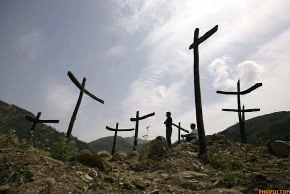 RNPS IMAGES OF THE YEAR 2009 - Earthquake survivors stand at the ruins of Donghekou Earthquake Site Park, a memorial park for Sichuan earthquake victims, in Qingchuan County, Sichuan Province, May 11, 2009. China tomorrow marks one year since the May 12 earthquake that devastated parts of the country's southwest.    REUTERS/Jason Lee (CHINA DISASTER ANNIVERSARY SOCIETY IMAGES OF THE DAY)