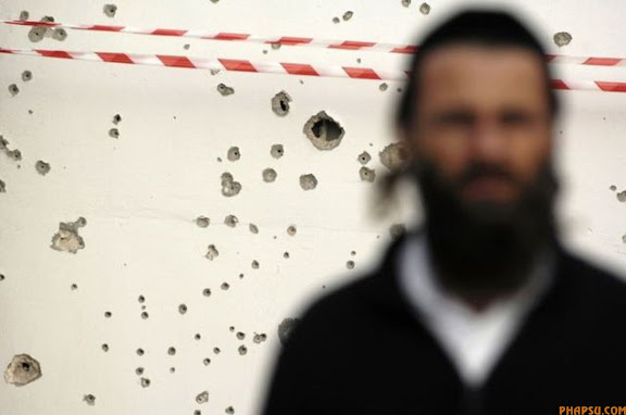 RNPS IMAGES OF THE YEAR 2009 - An ultra-Orthodox Jew stands near the site where a rocket fired by Palestinian militants in Gaza landed in the port city of Ashdod January 16, 2009. Israel said its Gaza offensive could be "in the final act" on Friday and sent envoys to discuss truce terms after Hamas made a ceasefire offer to end three weeks of fighting that has killed more than 1,100 Palestinians.  REUTERS/Amir Cohen (ISRAEL POLITICS CONFLICT)