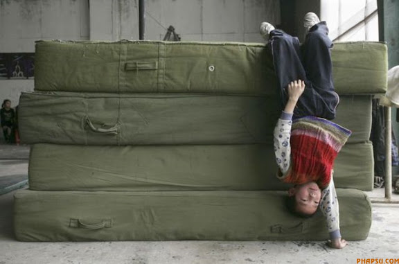 RNPS IMAGES OF THE YEAR 2009 - A boy practises handstand during a training session at a local acrobatic school in Zhengzhou, Henan province April 24, 2009. About 20 students, aged from 5 to 15, receive training at the school hoping to perform on stage after 3 or 4 years of practice to make a living, local media reported. Picture taken April 24, 2009. REUTERS/Eric Zhao (CHINA EDUCATION SOCIETY SPORT IMAGES OF THE DAY)
