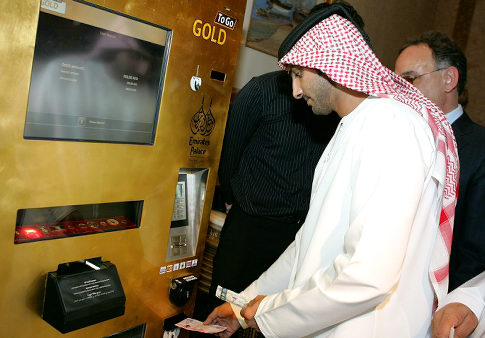 An Emirati man tries the "Gold to Go" vending machine at the Emirates Palace Hotel in Abu Dhabi on May 12, 2010. There's no mistaking what's in this vending machine. The well-heeled in the Gulf can now grab "gold to go" from a hotel lobby in the United Arab Emirates, when the need for a quick ingot strikes. The machine, itself covered in 24-carat gold, dispenses one, five and 10 gram bars as well as one ounce bars of gold. AFP PHOTO/EBRAHIM ADAWI (Photo credit should read EBRAHIM ADAWI/AFP/Getty Images)(Photo Credit should Read /AFP/Getty Images)   Original Filename: DV_To_Getty_3762636_0.jpg