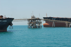 Two tankers fill their containers with oil from an Iraqi distribution platform at the Al Basrah Oil Terminal, 30 miles off the coast of Iraq.  (U.S. Army photo by Spc. Darryl Montgomery)