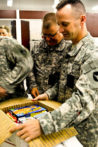 Spc. Mark Moritz, a Horseheads, N.Y. native and intelligence analyst with the IED Defeat team, 34th Inf. Div., opens a package from supporters at Alliant Techsystems June 13.  Alliant Techsystems adopted the team through the AdoptaPlatoon Soldier Support Effort, a nonprofit organization dedicated to serving deployed service men and women.