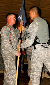 Lt. Col. Doug Cardinale, commander of 2nd Bn., 8th Inf. Regt., 2nd BCT, 4th Inf. Div., passes the guidon for Headquarters and Headquarters Company, 2nd Bn., 8th Inf. Regt., to Capt. Cash Freeman, incoming commander of HHC, during a change-of-command ceremony at Camp Wessam May 23. (U.S. Army photo by Sgt. Brandon LeFlore)