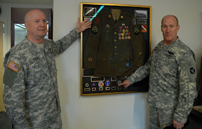 Maj. Gen. Rick Nash, commanding general of the 34th Red Bull Infantry Division, and Command Sgt. Maj. Doug Julin point out the patch of the Red Bulls, worn by the 442nd Regimental Combat Team when they fought under the 34th Red Bull Infantry Division during World War II. The Red Bull patch will again enter combat as the 34th Inf. Div. deploys to the southern sector of Iraq in mid-April. Red Bull Photo by Pfc. J.P. Lawrence