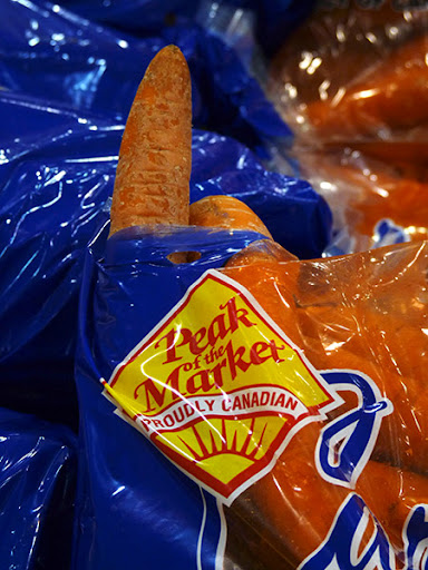 a carrot is poking out of a hole in a bag labelled 'peak of the market' a carrot is poking out of a hole in a bag labelled 'peak of the market'