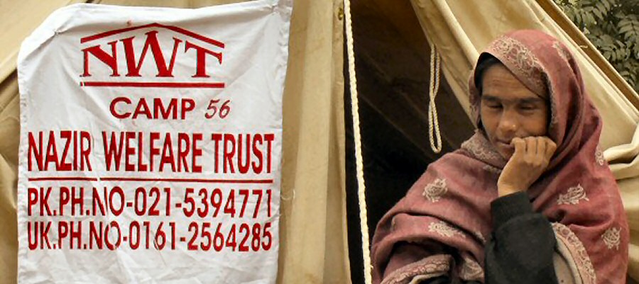 Photo of NWT supplied tent in Camp 56 and a Pakistani woman displaced by the 2005 Kashmir earthquake