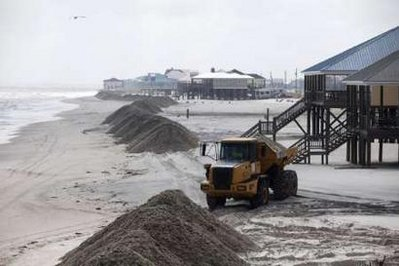 Crews build sand barriers in Dauphin Island, Alabama May 12, 2010 to protect it from the oil spill originated by the Deepwater Horizon wellhead. British  oil major BP said the oil spill in the Gulf of Mexico had cost it $450 million so far, an increase of $100 million on the figure reported earlier this week. REUTERS / Daniel Beltra / Greenpeace