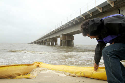 Kelly Maynard of Picayune surveys boom material washed up on the beach in downtown Bay St. Louis on Sunday. Maynard came to the Coast to fish, but was having second thoughts after hearing of many dead fish along the beach between Bay St. Louis and Waveland. Several thousand feet of boom has been deployed as the Mississippi Gulf Coast prepares for the effects of a massive oil slick coming from a leaking well in the Gulf of Mexico. JAMES EDWARD BATES / Sun Herald 