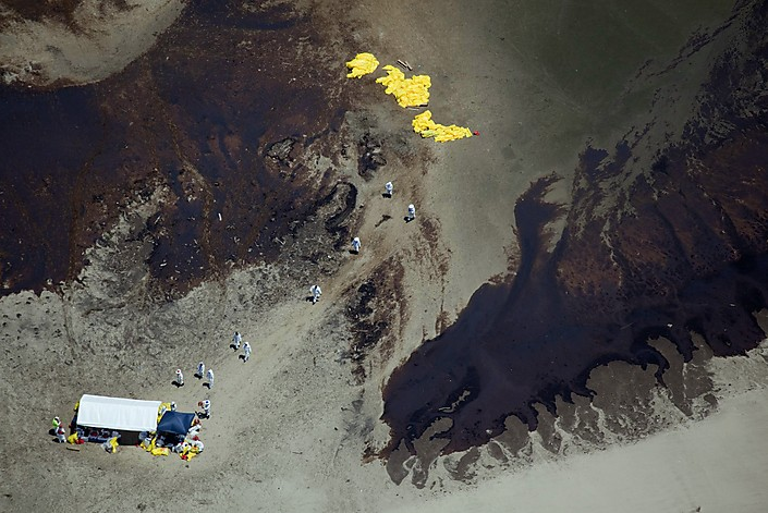 Crews try to clean an island covered in oil on the south part of East Bay, 23 May 2010. The U.S. government threatened to remove BP from efforts to seal a blown-out oil well in the Gulf of Mexico if it doesn't do enough to stop the leak, though the government acknowledged only the company and the oil industry have the needed know-how. Daniel Beltra / Greenpeace via Reuters