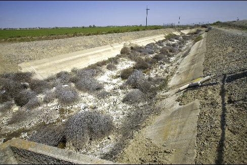 A feeder canal sits empty off the Delta Mendota Canal after the Federal Bureau of Reclamation instituted a “zero allocation” policy for irrigation water to farmers in Mendota, California, as seen on April 14, 2009. Photographer: Phil Hawkins / Bloomberg News