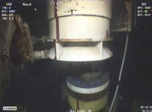 In this image taken from video provided by BP PLC at 18:17 CDT, a new containment cap, left, is lowered over the broken wellhead at the site of the Deepwater Horizon oil spill in the Gulf of Mexico, Monday, July 12, 2010. Deep-sea robots swarmed around BP's ruptured oil well Monday in a delicately choreographed effort to attach the tighter-fitting cap that could finally stop crude from gushing into the Gulf of Mexico nearly three months into the crisis. AP Photo / BP PLC