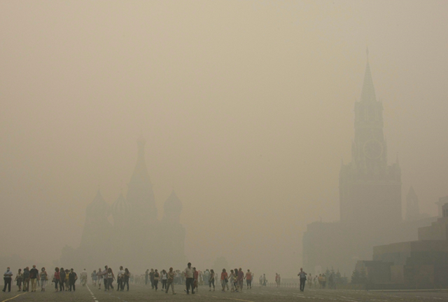 St. Basil's Cathedral, left, and the Kremlin, right, are seen as tourists walk through thick smog at Red Square in Moscow, Russia, Friday, Aug. 6, 2010. AP Photo / Mikhail Metzel