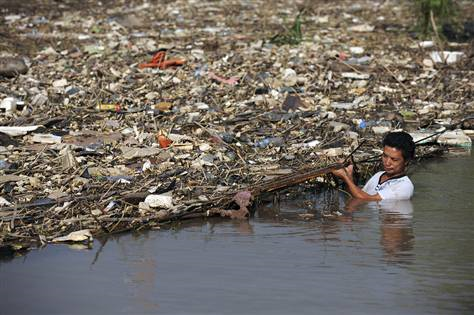 A worker clears floating garbage on the Yangtze River in Wuhu, China, on Monday, 2 August 2010. Jianan Yu / Reuters