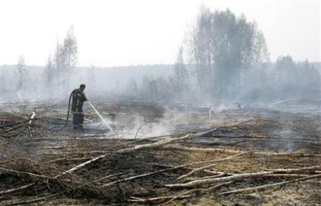 A firefighter works to extinguish a peat fire in a forest near the town of Shatura, some 130 km (81 miles) southeast of Moscow, July 27, 2010. Reuters / Denis Sinyakov