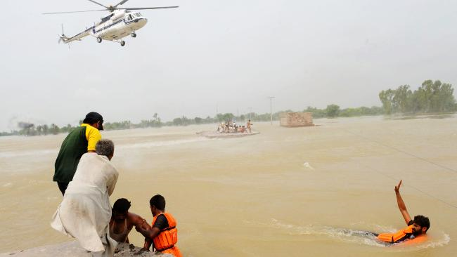 Pakistani rescuers help survivors in a flooded area of Khangarh. Source: AFP