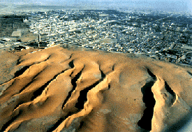 Linear dunes of the Sahara Desert encroach on Nouakchott, the capital of Mauritania. The dunes border a mosque at left. Georg Gerster / USGS