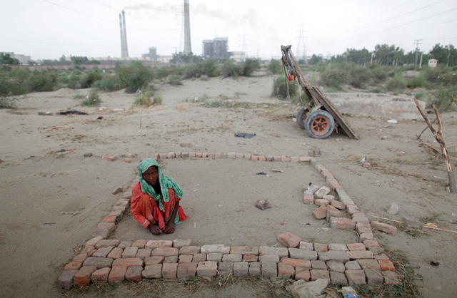 A flood victim collects bricks from abandoned buildings where her family found shelter in Pakistan's Muzaffargarh district on September 4, 2010. REUTERS / Damir Sagolj