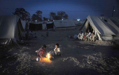 As winter sets in, IDPs in Pakistan huddle around a small fire at a camp in the Dera Ismail Khan district. Winterization of tents is going on and warm bedding is being distributed, but despite such efforts life is tough as temperatures fall steadily. © Abdul Majeed Goraya / IRIN