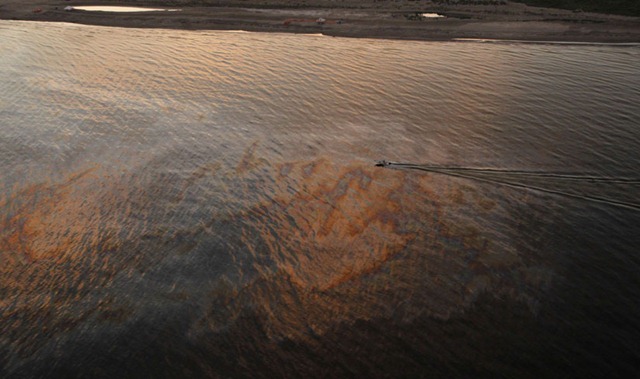 A boat motors through oil sheen from the Deepwater Horizon spill at sunset off East Grand Terre Island on the Louisiana coast. AP Photo