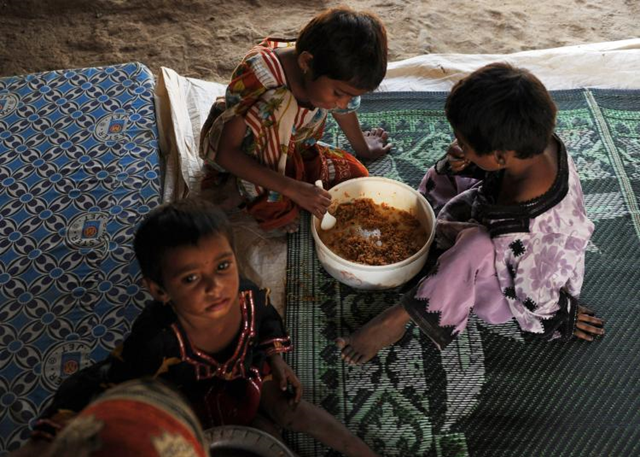 Pakistani children, displaced by floods, eat food at a makeshift camp in Karachi. Asif Hassan / AFP / Getty Images