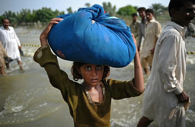 A Pakistani girl carrying her belongings on her head wades through flood waters in Punjab province's Basira on September 4, 2010. CARL DE SOUZA / AFP / Getty Images