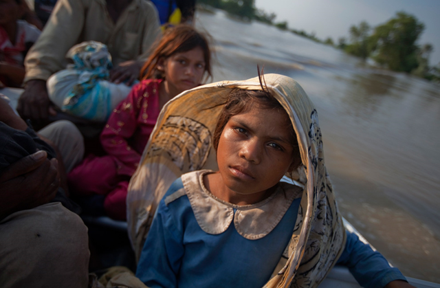 Nadia, who does not know her age, sits alongside siblings after they were rescued from rising floodwaters in Baseera, a village located in the Muzaffargarh district of Pakistan's Punjab province, August 10, 2010. REUTERS / Adrees Latif