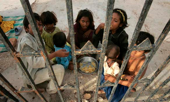 Flood survivors have a meal at a roadside in Thatta near Hyderabad, Pakistan, on 28 August 2010. Shakil Adil / Associated Press / cbc.ca