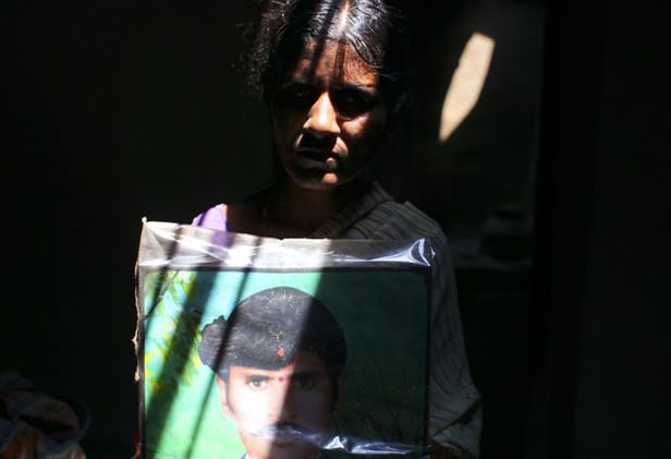 Sugali Nagamma holds a portrait of her husband, who killed himself by swallowing pesticide in front of her. Abbie Traylor-Smith / independent.co.uk