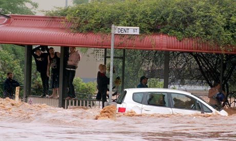 'The problem is rain' ... Clinging to railings on a flooded street, residents in Toowoomba are caught in floods that have devastated Australia&rsquo;s north-east in January 2011. Photograph: AP