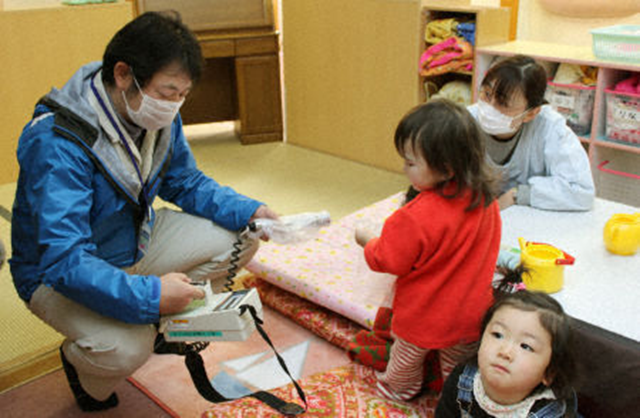 A public worker scans a toddler for radiation at a nursery center in the village of Iitate, Fukushima Prefecture, where radiation from the troubled Fukushima Daiichi nuclear power plant continues to be detected in the air, on April 6, 2011. The village decided to alleviate concern by evacuating pregnant women and parents with children under 3 years old, although it is not, for the most part, subject to the government's evacuation directive. Kyodo News