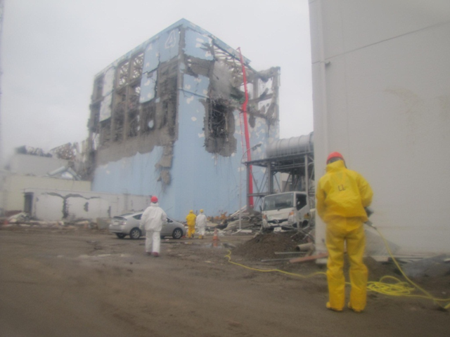 Workers at the Fukushima Daiichi nuclear plant outside of a wrecked reactor building. TEPCO / japannewstoday.com
