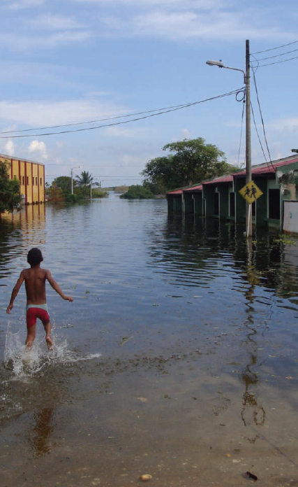 A boy in Atl&aacute;ntico, Colombia walks through his flooded town after torrential rains in December 2010. The unprecedented flooding affected some three million people in Colombia. Credit: UN Office for the Coordination of Humanitarian Affairs Colombia / refugeesinternational.org