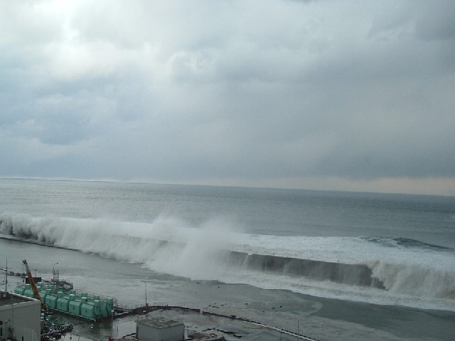 Tsunami wave approaches the Fukushima Daiichi Nuclear Power Station, 11 March 2011. The location is the slope at the eastern side of Radioactive Solid Waste Storage Facility (The east side of Unit 5 taken from the southern side of the unit). TEPCO
