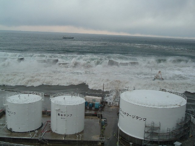 Tsunami wave destroys the sea wall the Fukushima Daiichi Nuclear Power Station, 11 March 2011. The location is the slope at the eastern side of Radioactive Solid Waste Storage Facility (The east side of Unit 5 taken from the southern side of the unit). TEPCO