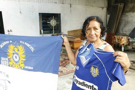 A Espoa de Bilha, Celeste, exibe a bandeira e a camisa com a qual ele ia ao estádio apoiar o Naça