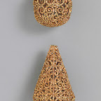 These beads feature superb patterns of scrolling vines whose bifurcations elegantly extend the design to fit the required space. The patterns recall those of the beveled style of the ninth century, although these possess clearer lines, perhaps owing to the medium.