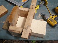 My prototype of a guide for splitting firebricks with the chisel pictured.  This design fails to allow for clearance for the chisels handle.